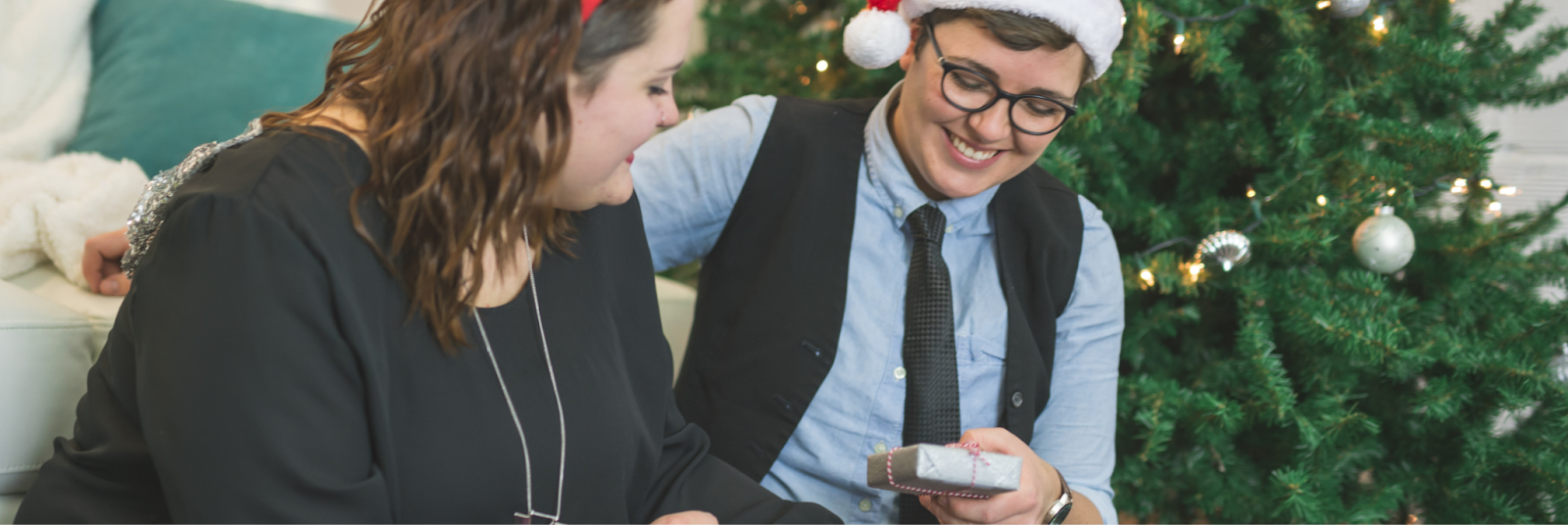 An LGBTQ+ couple joyfully exchanging thoughtful gifts on Christmas Day, smiling at each other in a moment of love and celebration. They have overcome holiday depression. 