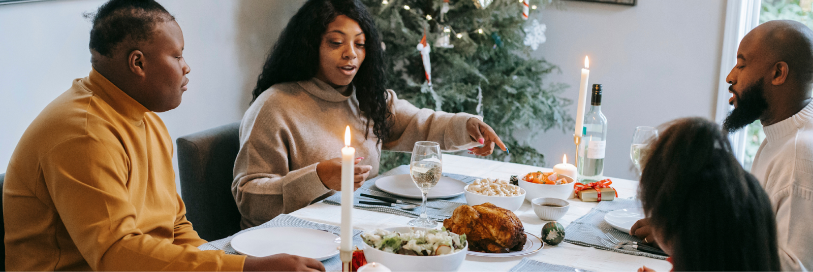 A family gathered around the holiday table, sharing a meal together; though there’s a hint of tension in the air, they are still enjoying each other's company and making the best of the moment. They are overcoming holiday depression together.